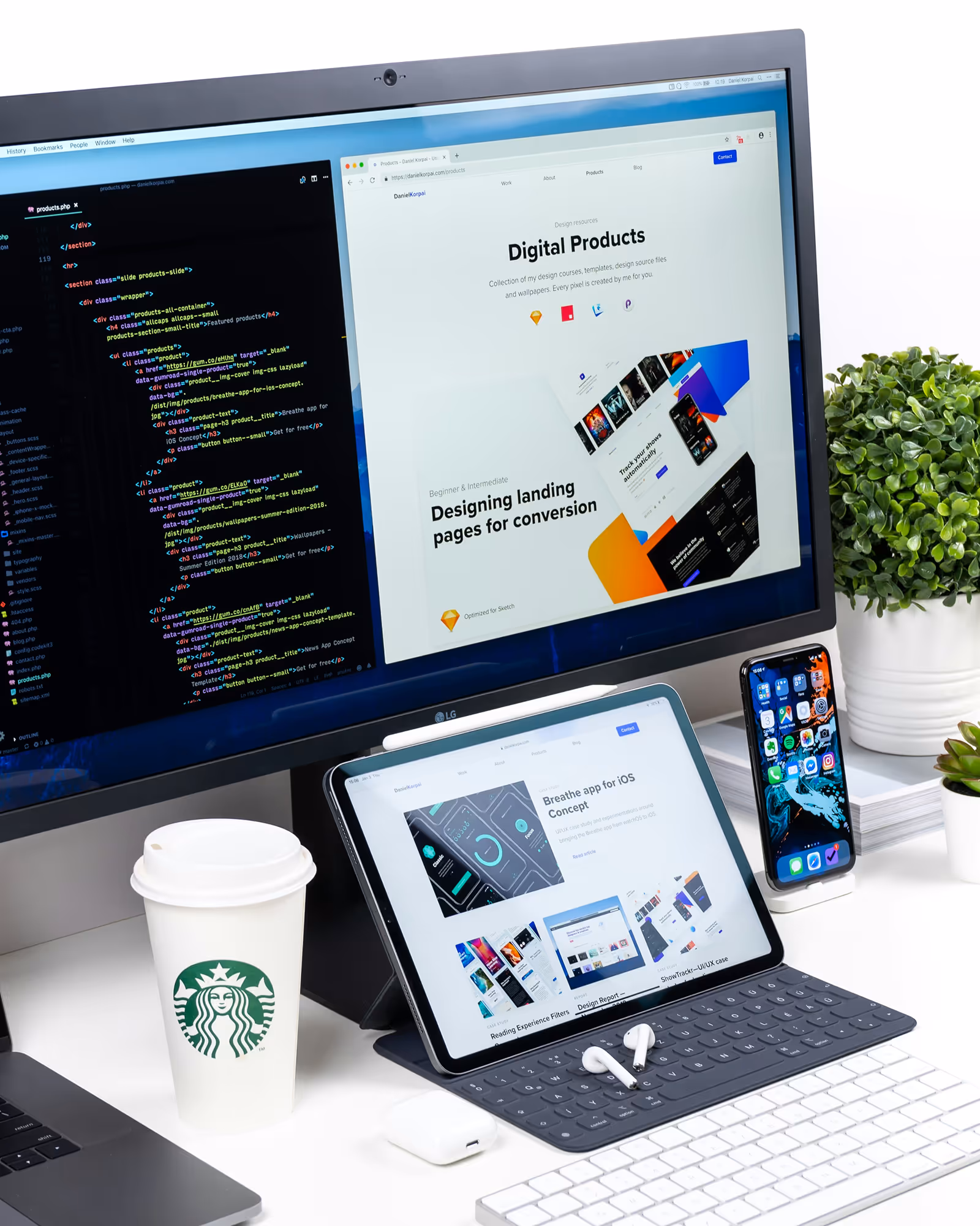 Workspace with a monitor showing code and a digital products web page, a tablet with design content, a smartphone, a Starbucks cup, wireless earbuds, and a potted plant.